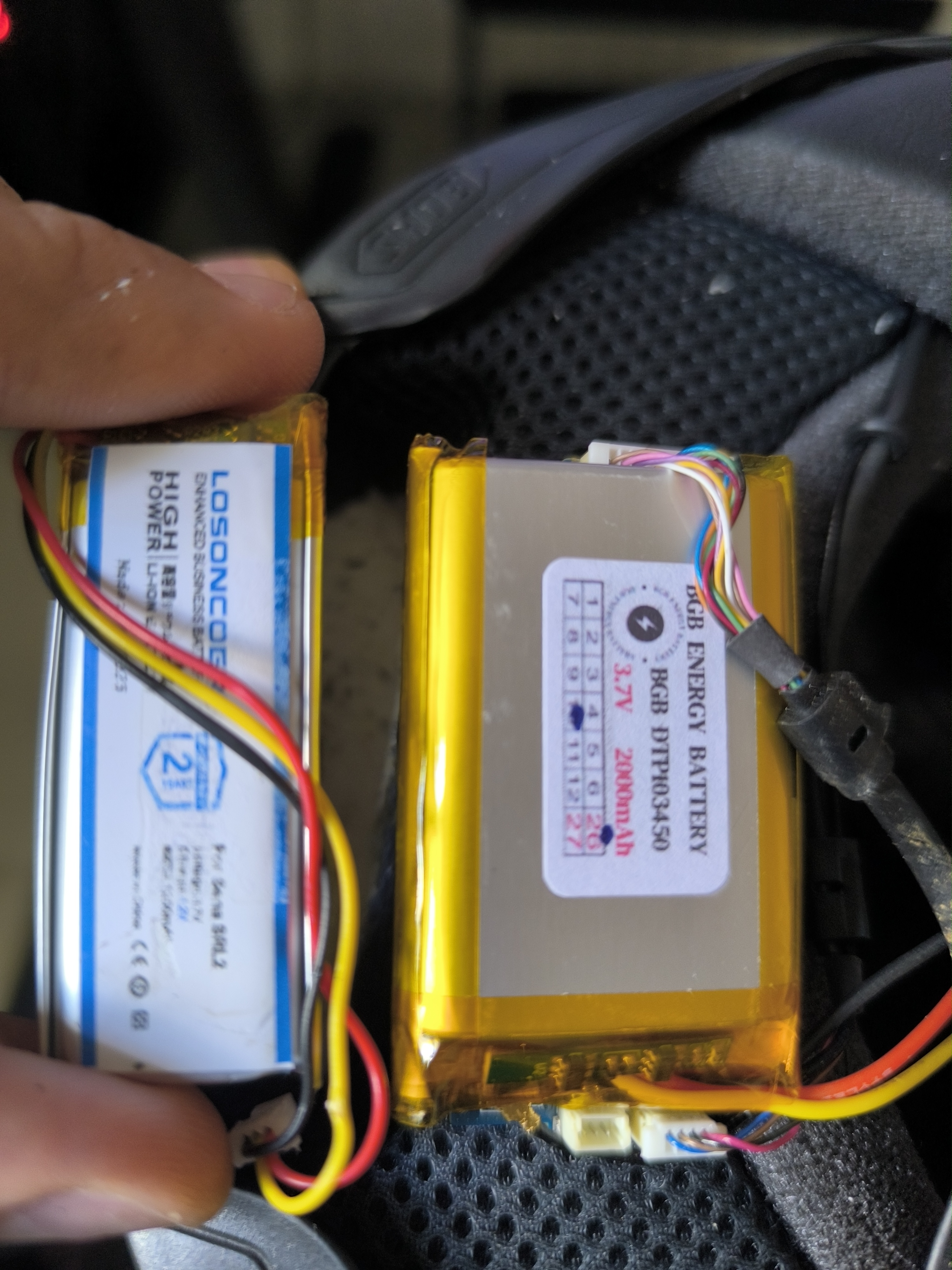 The replacement battery's BGB DTP103450 label beside the removed battery and the SRL2 wiring.